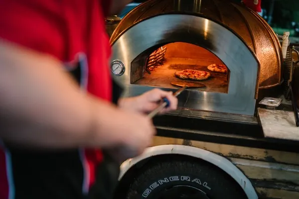 Wood-fired pizza being crafted in our mobile oven at a wedding
