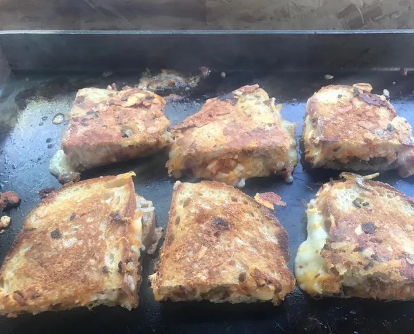 Batch of gourmet grilled cheese sandwiches on the griddle