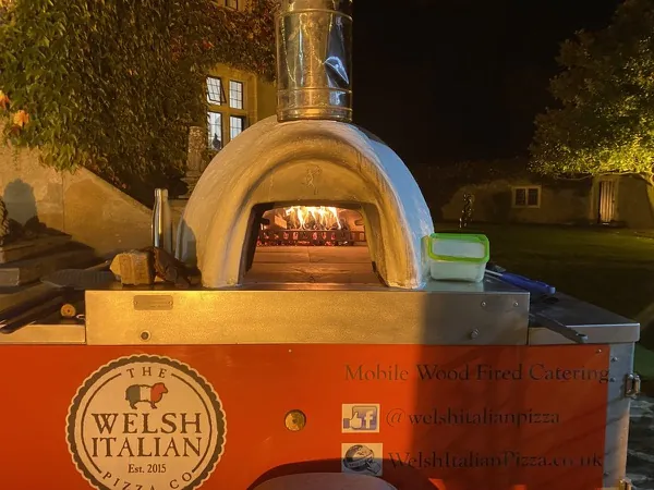 Pizza being pulled from our copper dome wood-fired oven